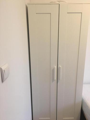 弗罗茨瓦夫Hallera Wroclaw的卧室内带两扇门的白色衣柜