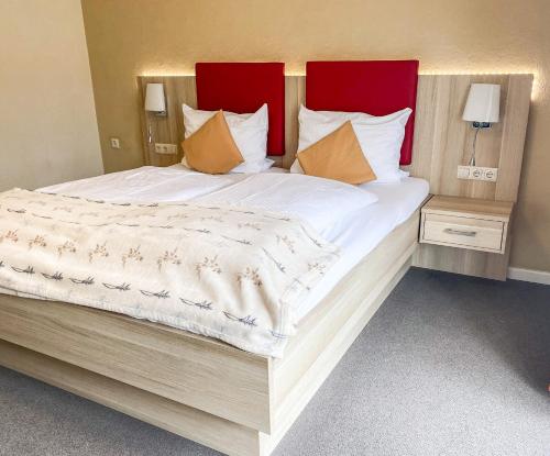 圣彼得奥尔丁Hotel Garni Silvana的一张大床,配有红色和白色的床单和枕头