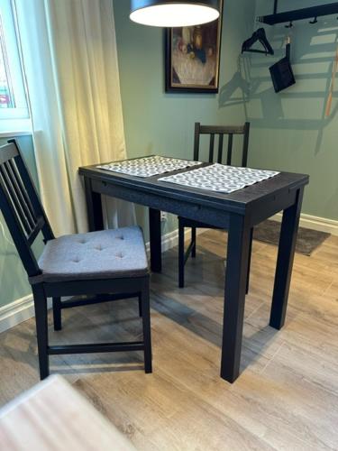 诺尔泰利耶Dalkärret的一张带两把椅子的黑桌、一张桌子和一张桌子以及一把椅子