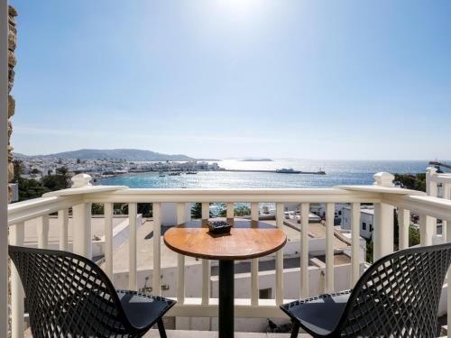 米克诺斯城Yalos Hotel Sunset view Mykonos town private rooms的海景阳台上的桌子
