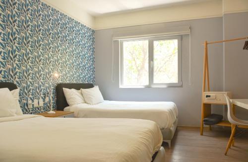 墨西哥城Casa Condesa Michoacan 113的配有两张蓝色和白色壁纸的床铺