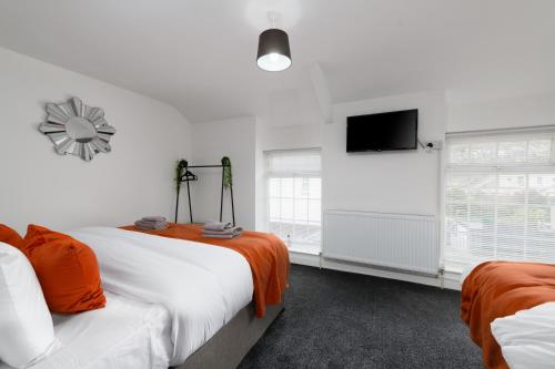 Modern House near Washeries Park的一间卧室配有两张床和一台平面电视