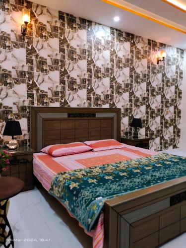 拉合尔VIP Luxury Room's的一间卧室配有一张床和一张带照片的墙壁