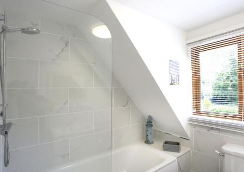 洛斯托夫特Ash的带淋浴和盥洗盆的白色浴室