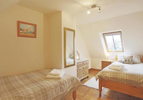 洛斯托夫特Ash的一间卧室配有两张床、镜子和梳妆台