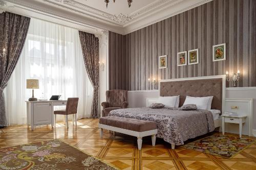 利沃夫摩登艺术酒店的一间卧室配有一张床、一张桌子和一把椅子