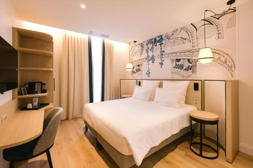 波尔多梅杰斯提科酒店的一间酒店客房,配有一张白色的床和一张书桌