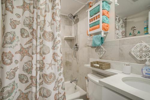 威尔伍德克拉斯特Wildwood Crest Condo with Pool and Beach Access!的浴室配有淋浴帘、卫生间和盥洗盆。