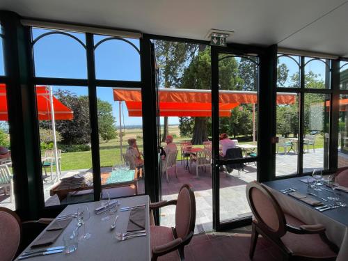 WisquesLogis - Hotel Restaurant La Sapinière的用餐室设有桌椅和窗户。