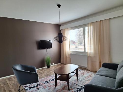 VolttiJääskän Loma, Kojolapark asunto 2的带沙发、桌子和窗户的客厅