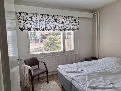 VolttiJääskän Loma, Kojolapark asunto 2的卧室配有床、椅子和窗户。