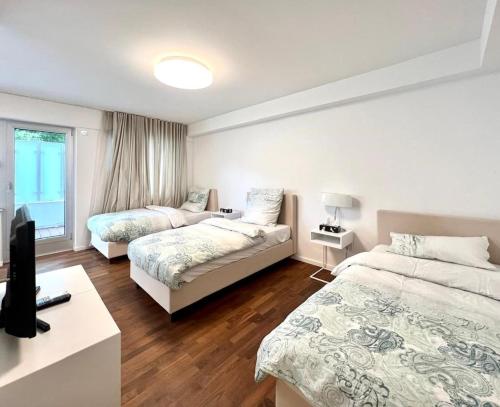 杜塞尔多夫Villa Düsseldorf的一间带两张床的卧室和一台电视