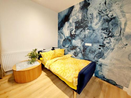 SiechniceLuxury modern new apartment with garden Siechnice的一间卧室配有黄色的床和绘画