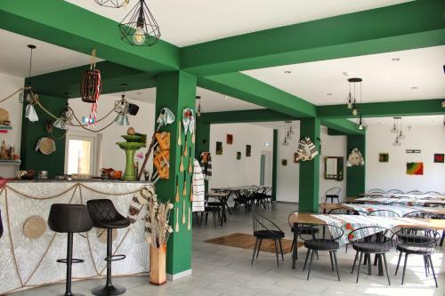 坎普朗莫道尼斯Păunașul Codrilor的餐厅拥有绿色的墙壁和桌椅