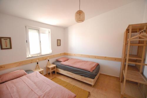 拉波塞拉Happy Hostel Sagres的一间卧室设有两张床和窗户。