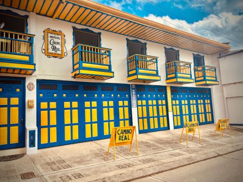 萨兰托Hospedaje Camino Real a 150 MTS del centro的一座建筑,设有蓝色和黄色的门和两把椅子