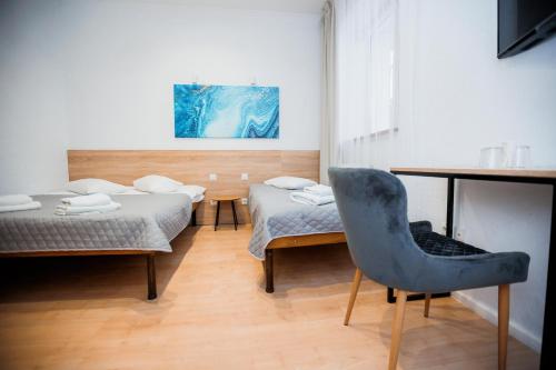 利沃夫斯达伊哈尔科夫酒店的客房设有两张床、一张桌子和一把椅子。
