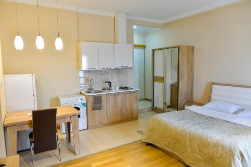 库塔伊西Cozy Apartment In Old Town Kutaisi的一间带一张床和一张书桌的卧室和一间厨房