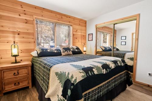 大熊湖Catalina Creekside Cabin - Log home with wood burning fireplace for an immersive mountain getaway!的一间卧室配有两张床和镜子