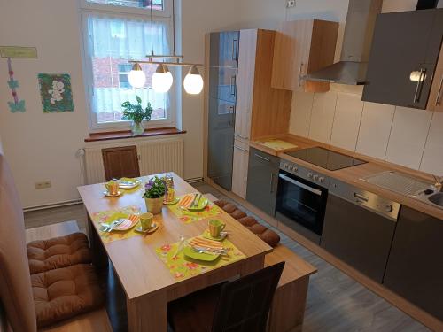 布兰肯堡Holiday Home Schloßblick的一间带木桌的厨房和一间带炉灶的厨房