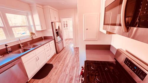 洛杉矶Los Angeles Dream Cottage的厨房配有白色橱柜、水槽和炉灶。