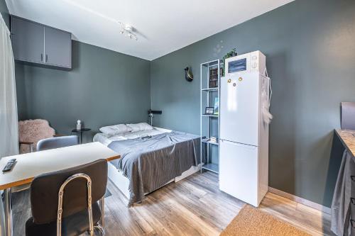 雷克雅未克Charming cottage in downtown Reykjavik - Birta Rentals的小房间设有一张床和一台冰箱
