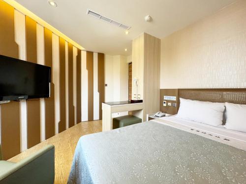 台中市爱莱时尚旅馆的配有一张床和一台平面电视的酒店客房