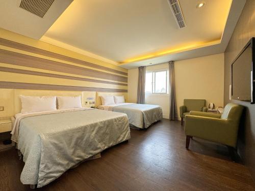 台中市爱莱时尚旅馆的一间酒店客房,设有两张床和电视