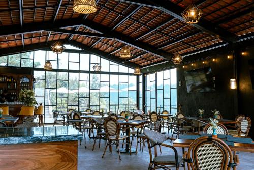 TlatlauquitepecHotel Casa Xaa的用餐室设有桌椅和窗户。
