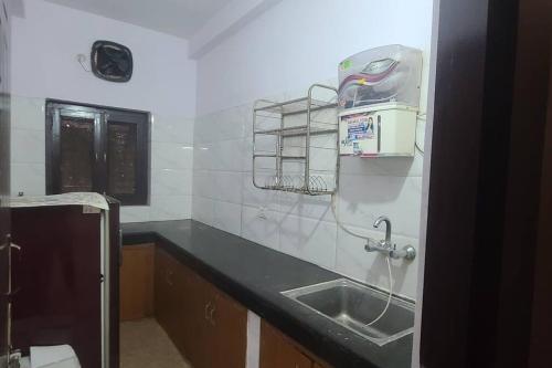 范兰德凡Atithi Devo Bhava - RadhaNiwas的厨房配有水槽和墙上的用具