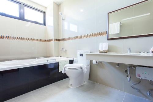 武里南西塔公主酒店的一间带卫生间、水槽和镜子的浴室