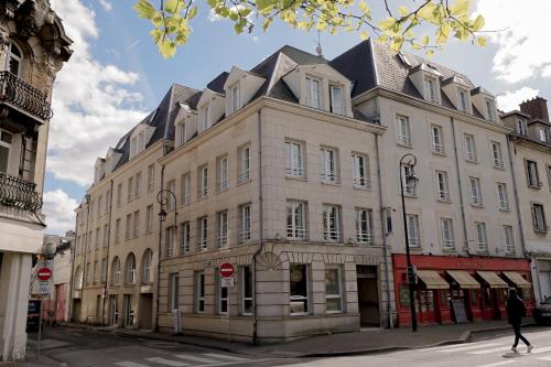 贡比涅ALFRED HOTELS Compiègne Ex Hôtel des Beaux-Arts的街道拐角处的大建筑