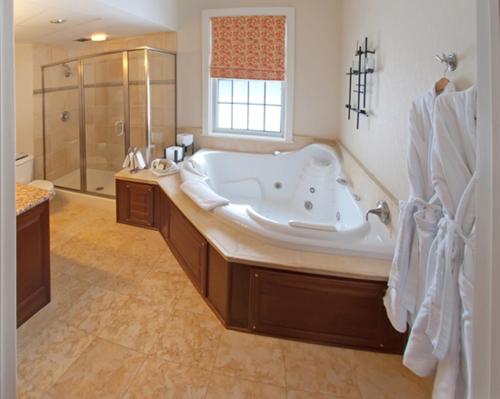 伯灵顿The Essex Resort & Spa的大型浴室设有大型浴缸和淋浴。