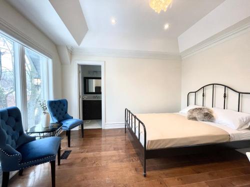 多伦多Vihome520-Beautiful house near North York Center的一间卧室配有一张床和两张蓝色椅子