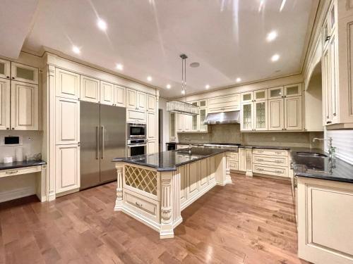 多伦多Vihome520-Beautiful house near North York Center的一间大厨房,配有白色的橱柜和黑色的台面