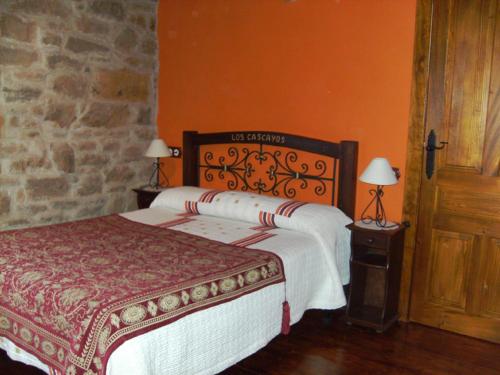 AbantroLos Cascayos的一间卧室设有一张大床和橙色的墙壁