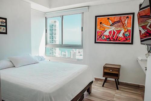 卡塔赫纳Playa Cartagena Apartments的白色的卧室设有床和窗户