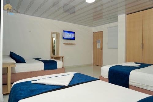 圣玛尔塔Hotel Perla del Caribe的一间酒店客房,设有两张床和电视