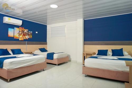 圣玛尔塔Hotel Perla del Caribe的一间卧室设有两张带蓝色墙壁的床