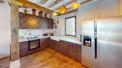 Bordeaux-Saint-ClairChâteau de Saint-Clair的厨房配有木制橱柜和不锈钢冰箱。