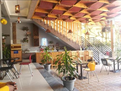 Debre ZeyitEkshesh Hotel Bishoftu的一间带桌椅的餐厅,以及楼梯