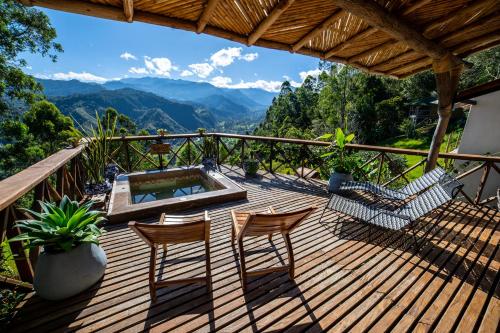 萨兰托Hotel Kawa Mountain Retreat的一个带椅子和热水浴缸的甲板和山脉