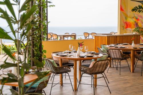 奥拉涅斯塔德Golden Rock Dive and Nature Resort的餐厅设有桌椅,以大海为背景