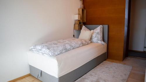 因斯布鲁克Eva Apartments - Nordkette的一张带白色床单和枕头的小床