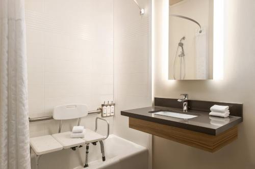 河边城Candlewood Suites Aberdeen-Bel Air, an IHG Hotel的浴室配有盥洗盆和浴缸。