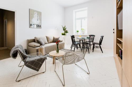 卢布林布罗哇佩拉公寓 - 佩拉啤酒厂的客厅配有沙发、椅子和桌子