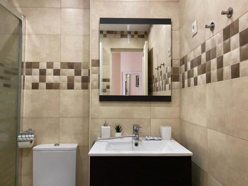 贝纳尔马德纳Apartamentos Benal Beach Group的一间带水槽、卫生间和镜子的浴室