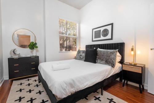 洛杉矶Sleek & Upscale: Premier 1-BR Apartment in LA!的一间卧室配有一张大床和镜子