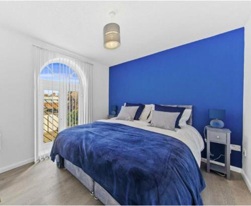 北安普敦Stylish 2 bedroom Apartment in Kettering Town Centre, sleeps 4, free parking, wifi, Sky, Netflix的蓝色的卧室,配有一张蓝色墙壁的床