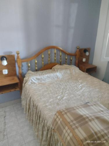La ConsultaCasa manu的一间卧室配有一张带木制床头板的床